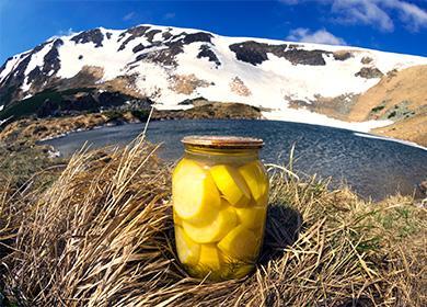 Банка с консервирани тиквички на фона на планини